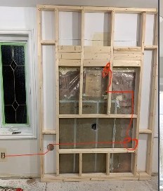 The feature wall framed in timber before boarding, with wiring run for the fireplace