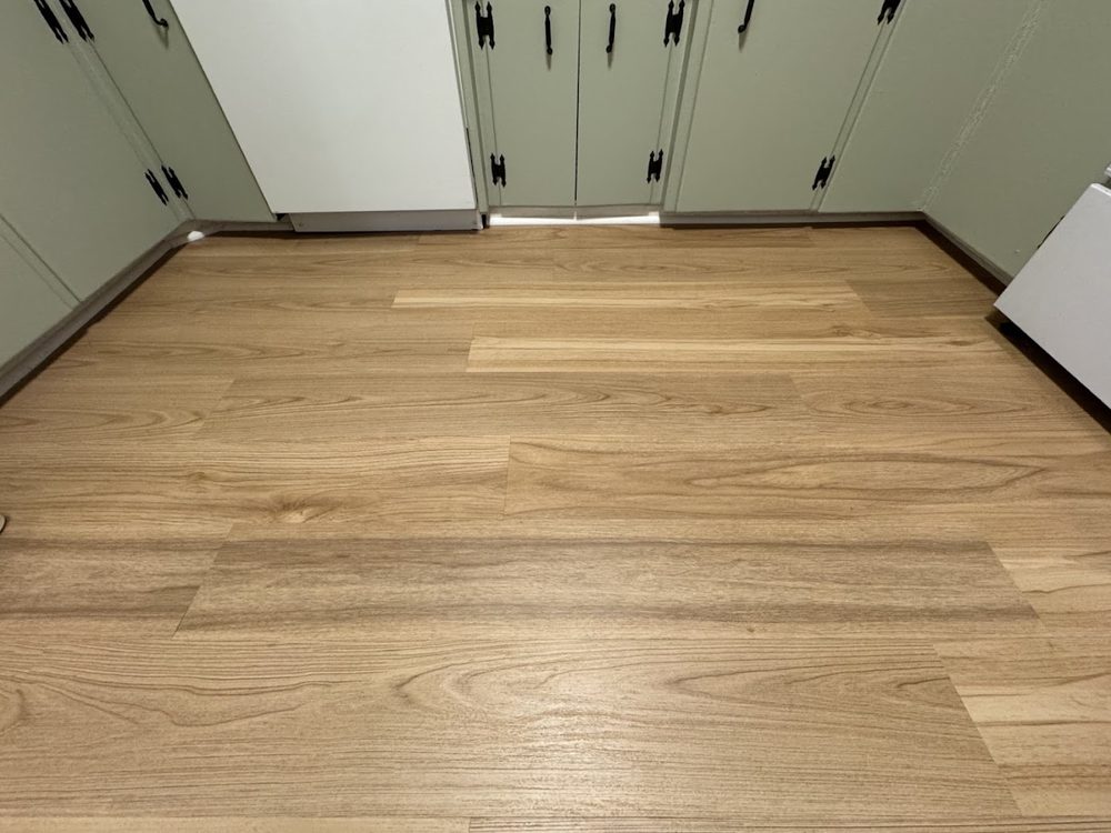 New light wood-look plank flooring in a room with sage green closet doors