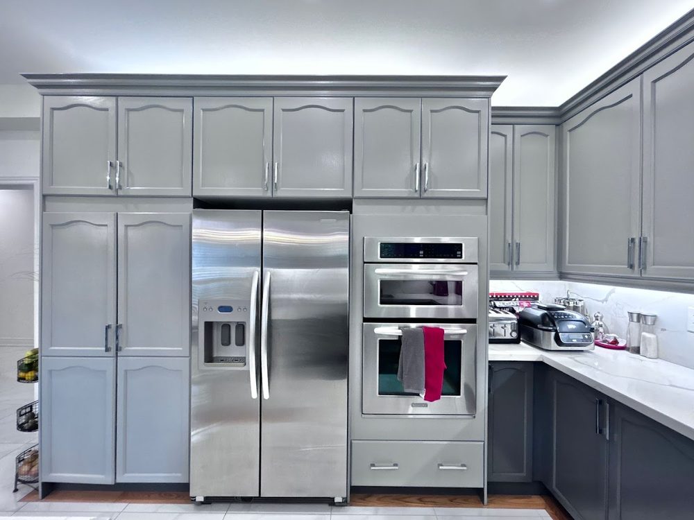 Tall grey cabinets around a stainless fridge and double wall oven