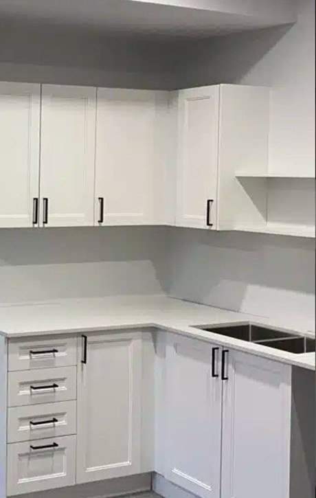 New white shaker kitchen cabinets with a quartz countertop and undermount sink