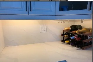 New white quartz counter and backsplash under white upper cabinets