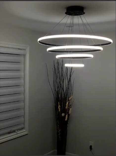 A black multi-ring pendant light above a window with zebra blinds