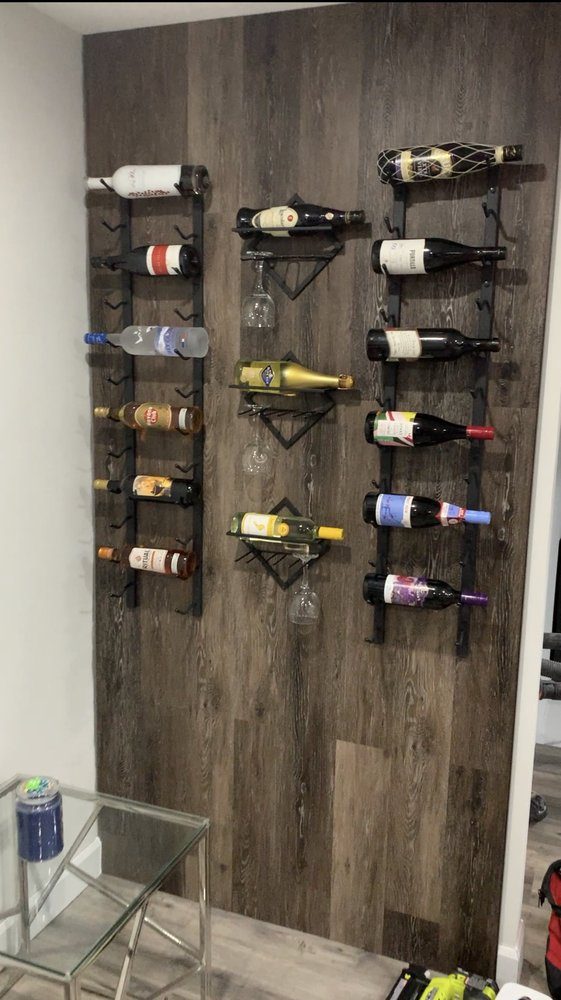 A dark wood-look feature wall with a mounted metal wine rack